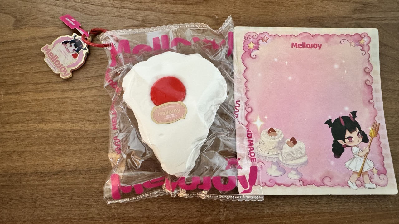 中身は台紙とスクイーズ本体。左上にはカラビナと可愛いチャームが付属。