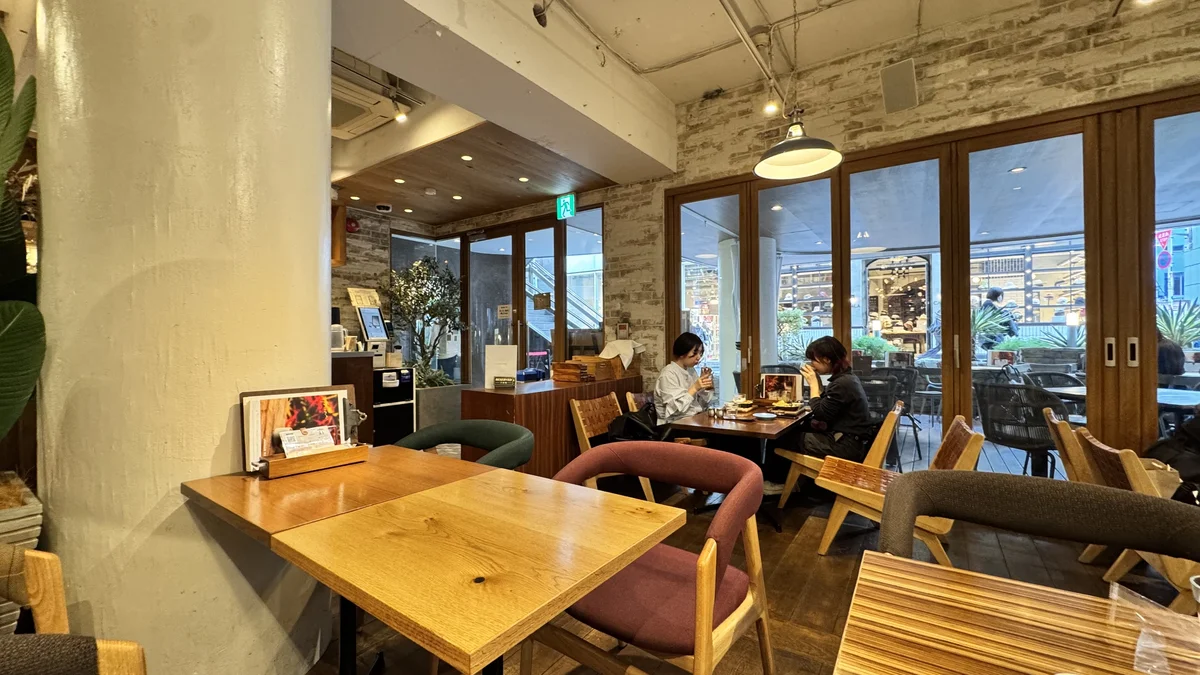 JINNAN CAFE渋谷1Fの窓側テーブル席。白レンガ壁と大きな窓が開放的