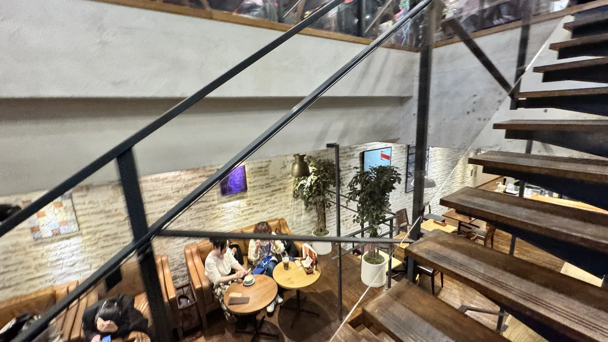 JINNAN CAFE渋谷の吹き抜け階段から地下フロアを見下ろす