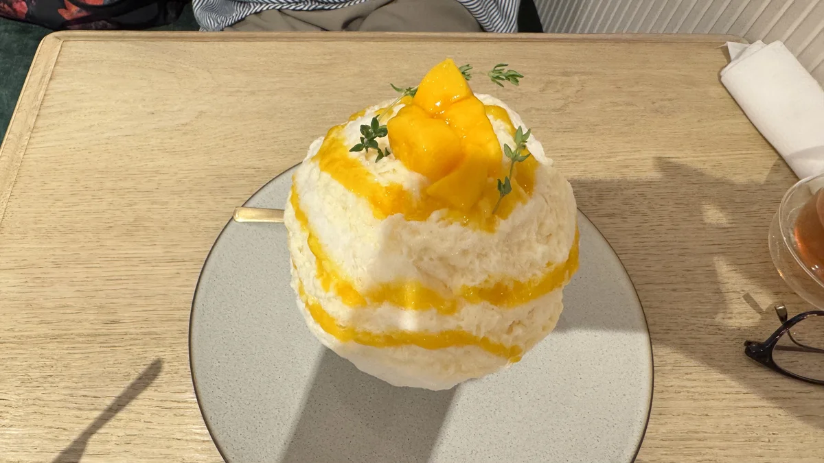 CUPS 表参道店のマンゴーアングレーズかき氷を真上から撮影。ミルク味のかき氷にマンゴーソースとフレッシュマンゴー