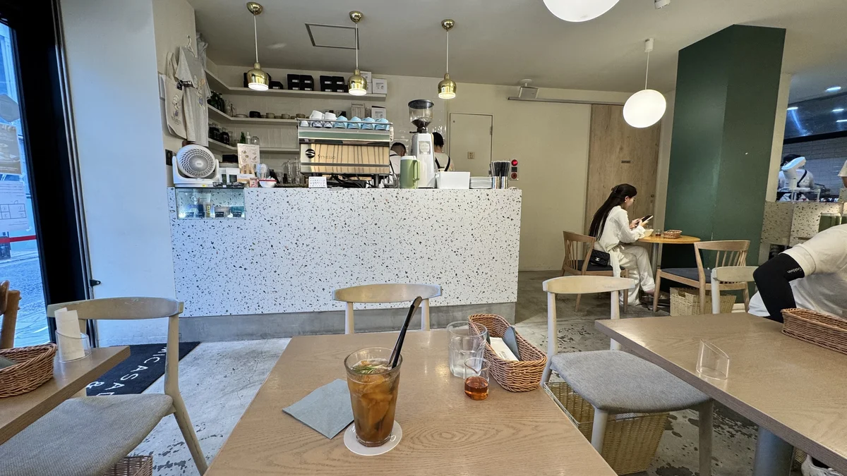 ミカサデコ&カフェの店内席。白い服装の女性がスマートフォンを見ながら過ごす様子