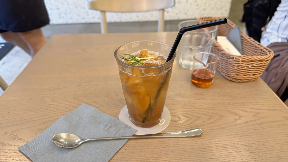 ミカサデコ&カフェの「ごろっとパイナップルのティーソーダ」。ローズマリーを添えたアイスドリンク