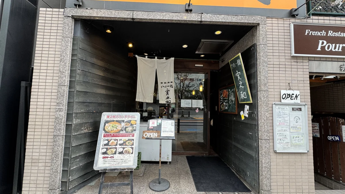 麺酒房 実之和 赤坂店の入口全景。白いのれんと「実之和のランチタイム」のメニュー看板
