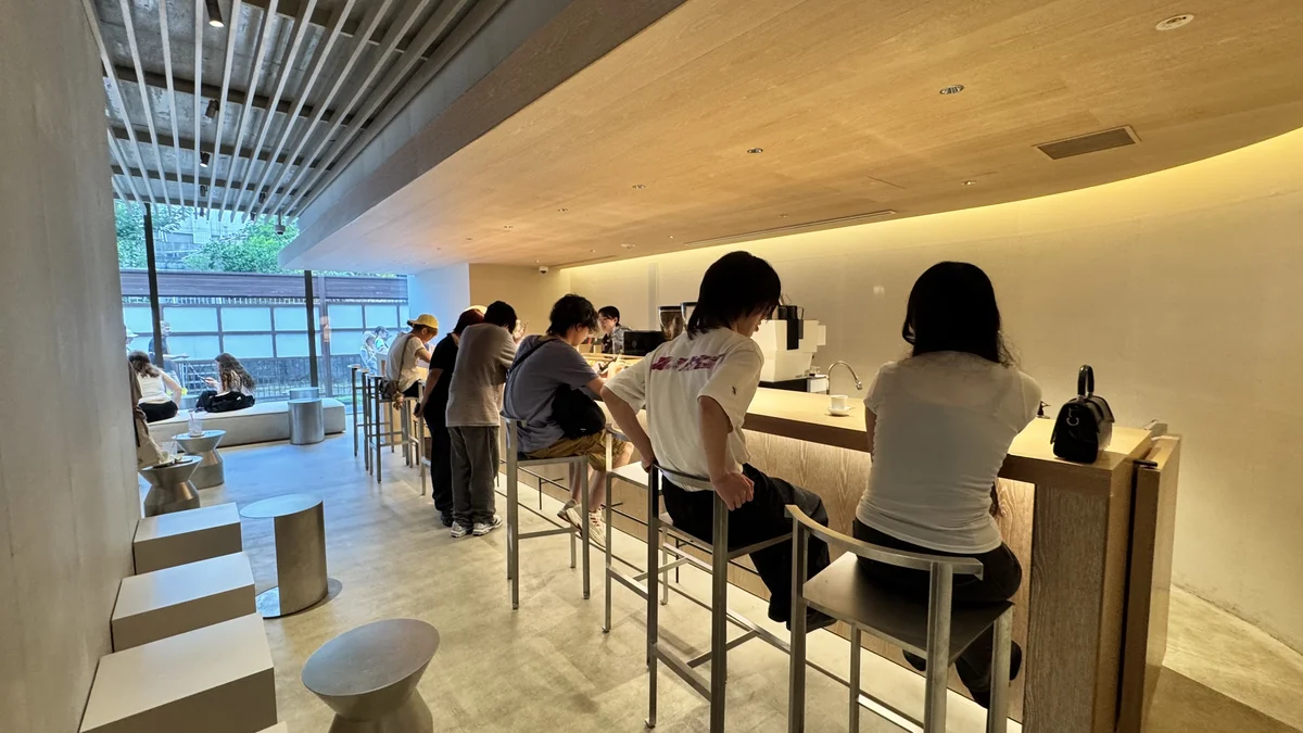 QUARO 2階のバーカウンター席で過ごす来店客たち、窓の外には緑が見える