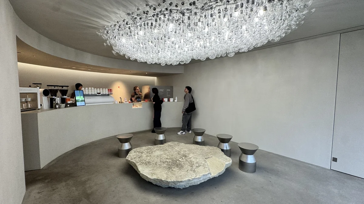 QUARO B1フロアのカウンターでスタッフと会話する来店客、頭上には大きなガラス玉のシャンデリア