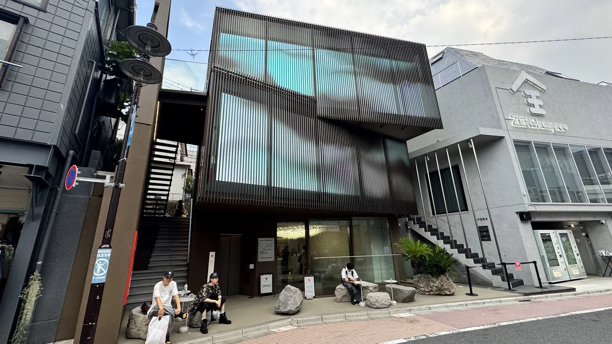 QUAROの外観を日中に撮影。1階の「OPEN」看板と、岩を配したテラス席