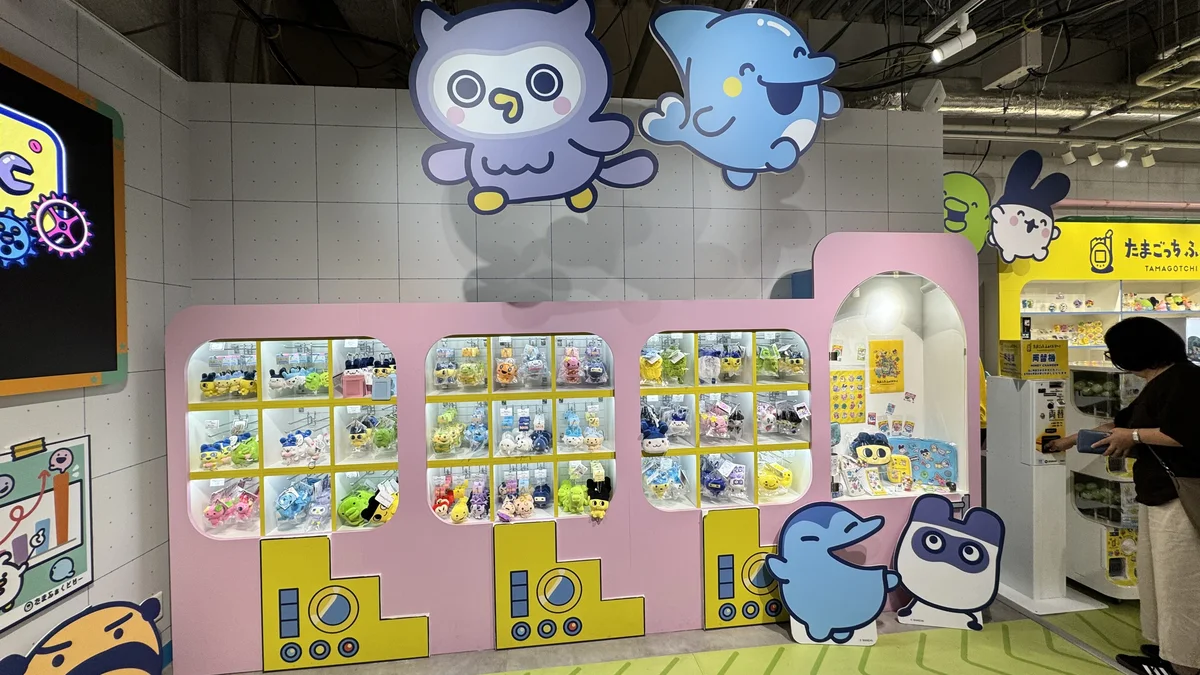 たまごっち ふぁくとり～！フクロウ型・イルカ型キャラクターの壁面オブジェとピンクのガシャポン什器