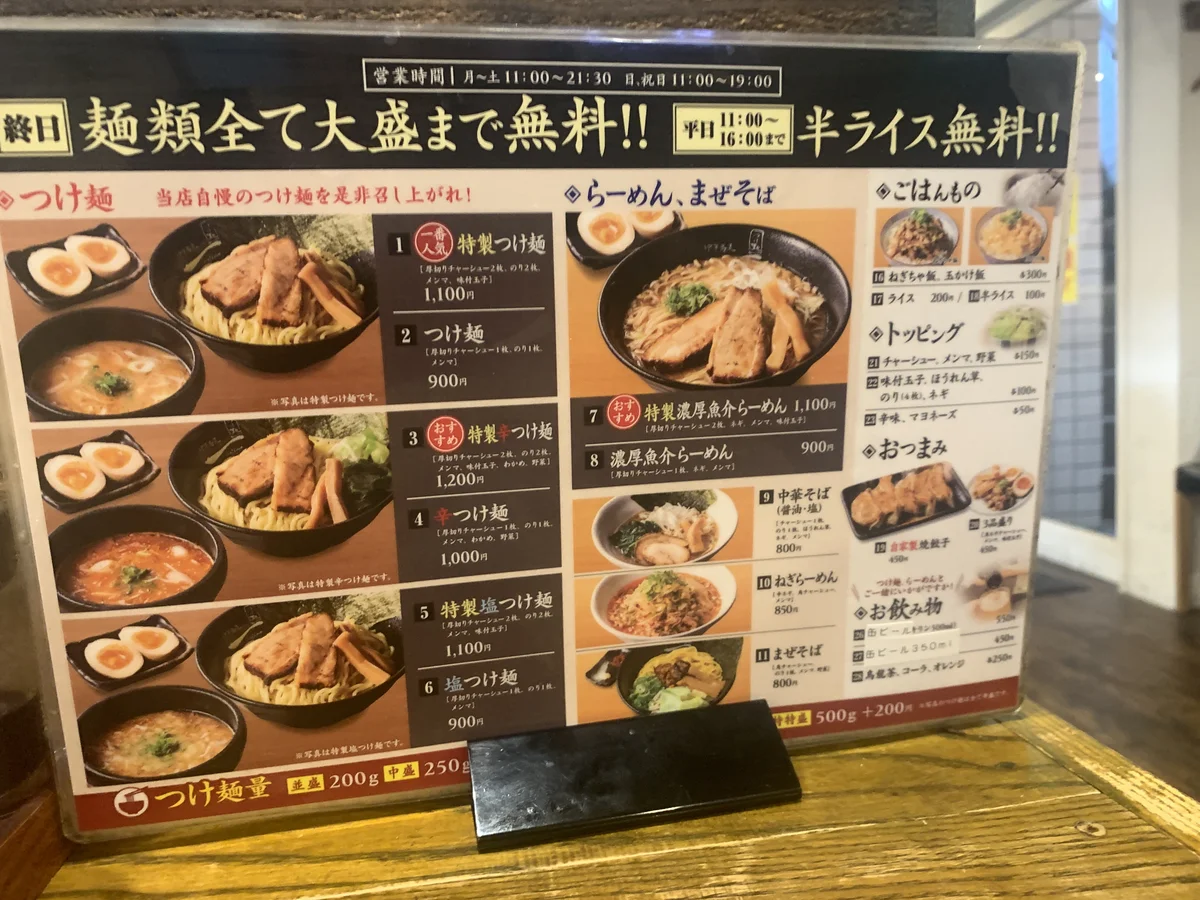 一(hajime)原宿店のメニュー看板。特製つけ麺や特製濃厚魚介らーめんなど写真付きで紹介