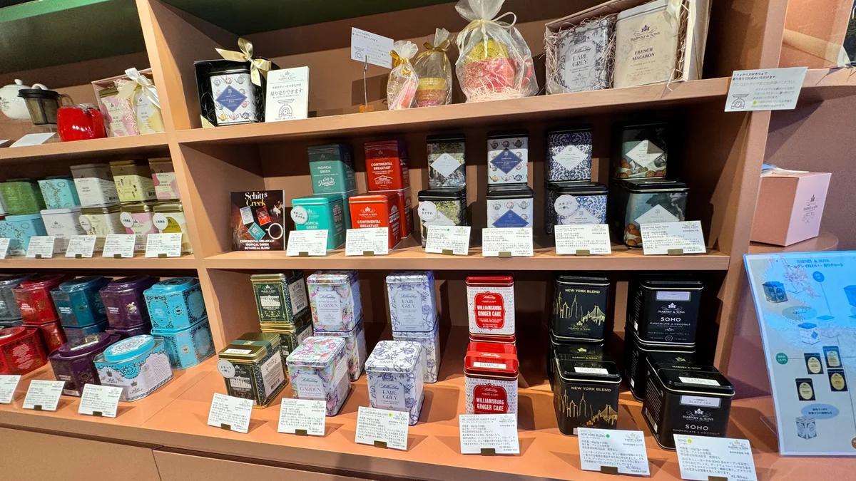 A shelf lined with HARNEY & SONS tins bearing place names such as Williamsburg, New York Blend, and SOHO